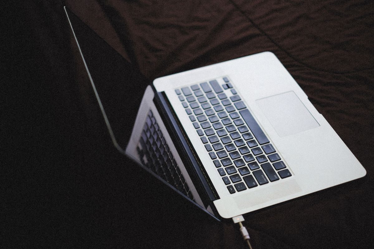Laptop moderna con teclado retroiluminado y cargador conectado