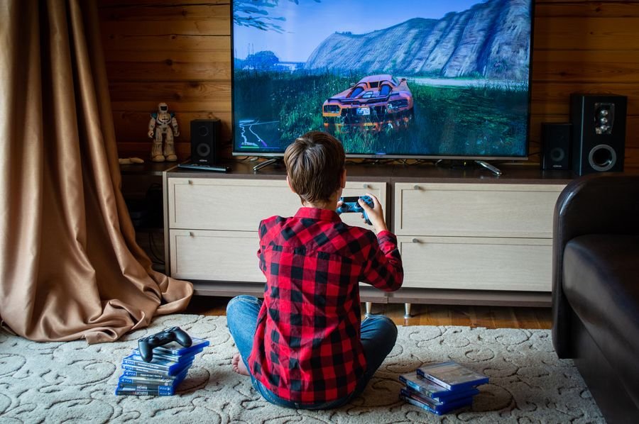 Niño jugando videojuegos en consola PS5