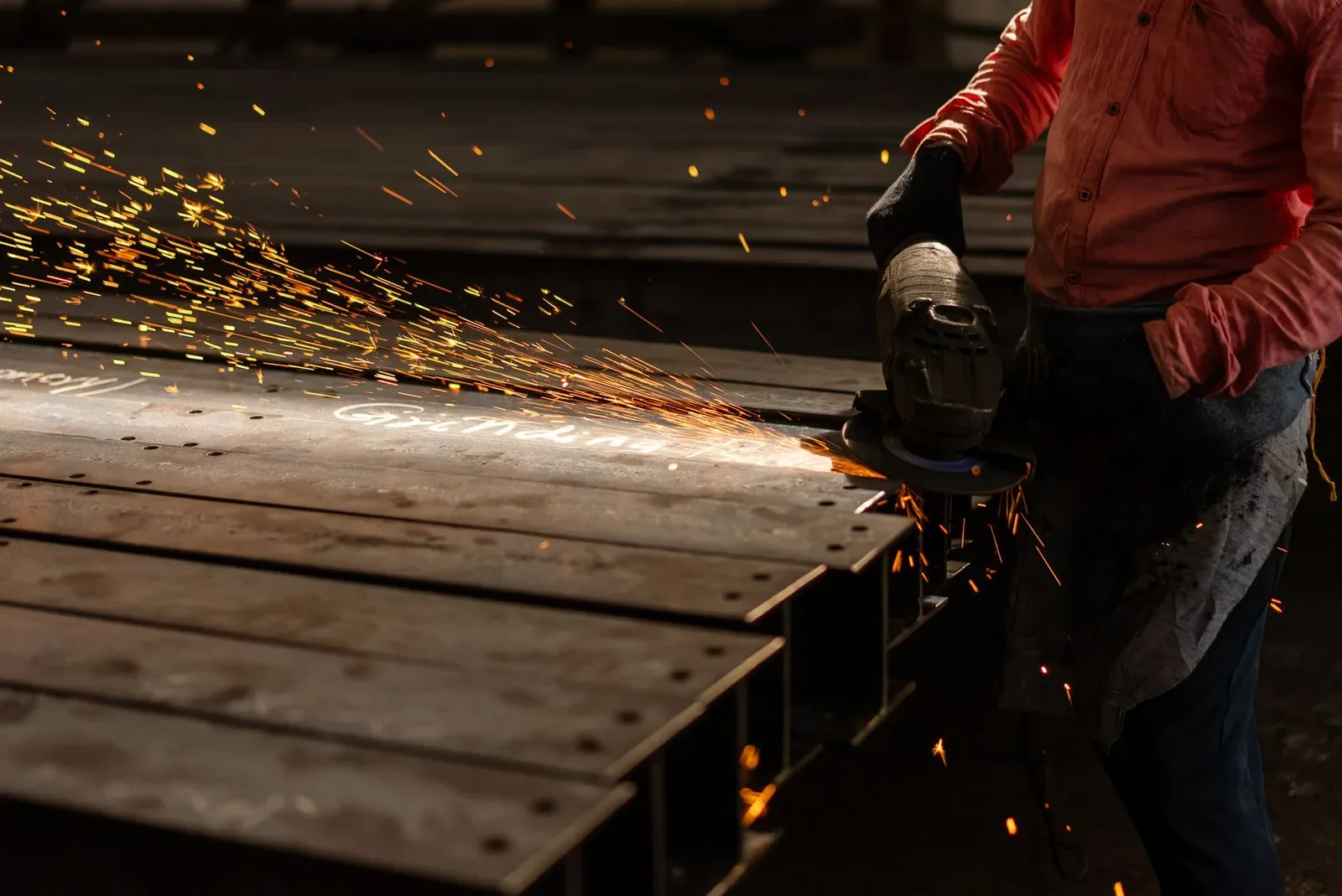 Amoladora angular cortando metal con chispas en un taller