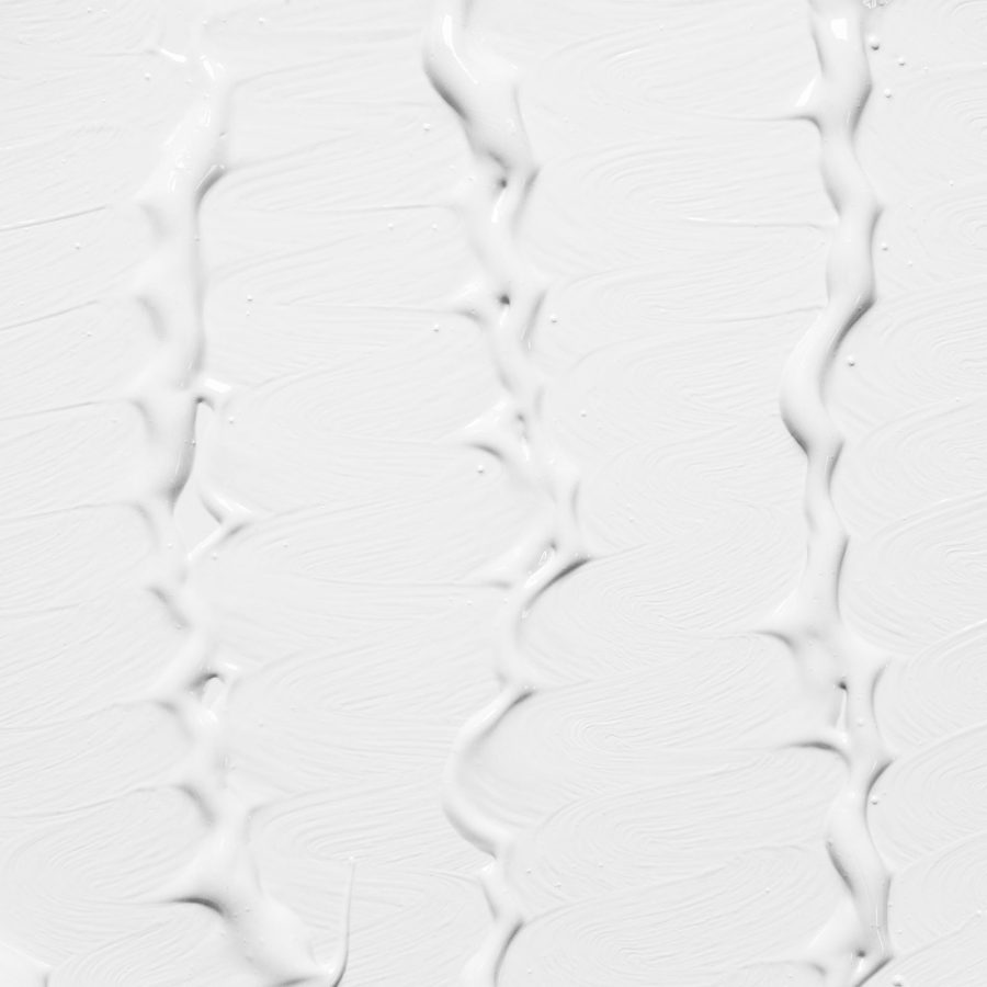 Textura de crema corporal extendida sobre la piel del antebrazo