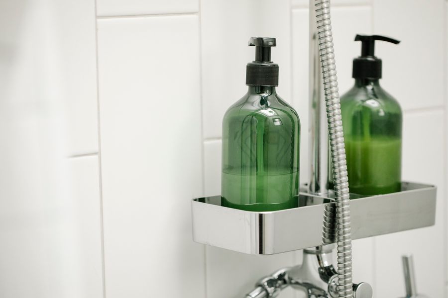 Dispensadores verdes de loción corporal en baño